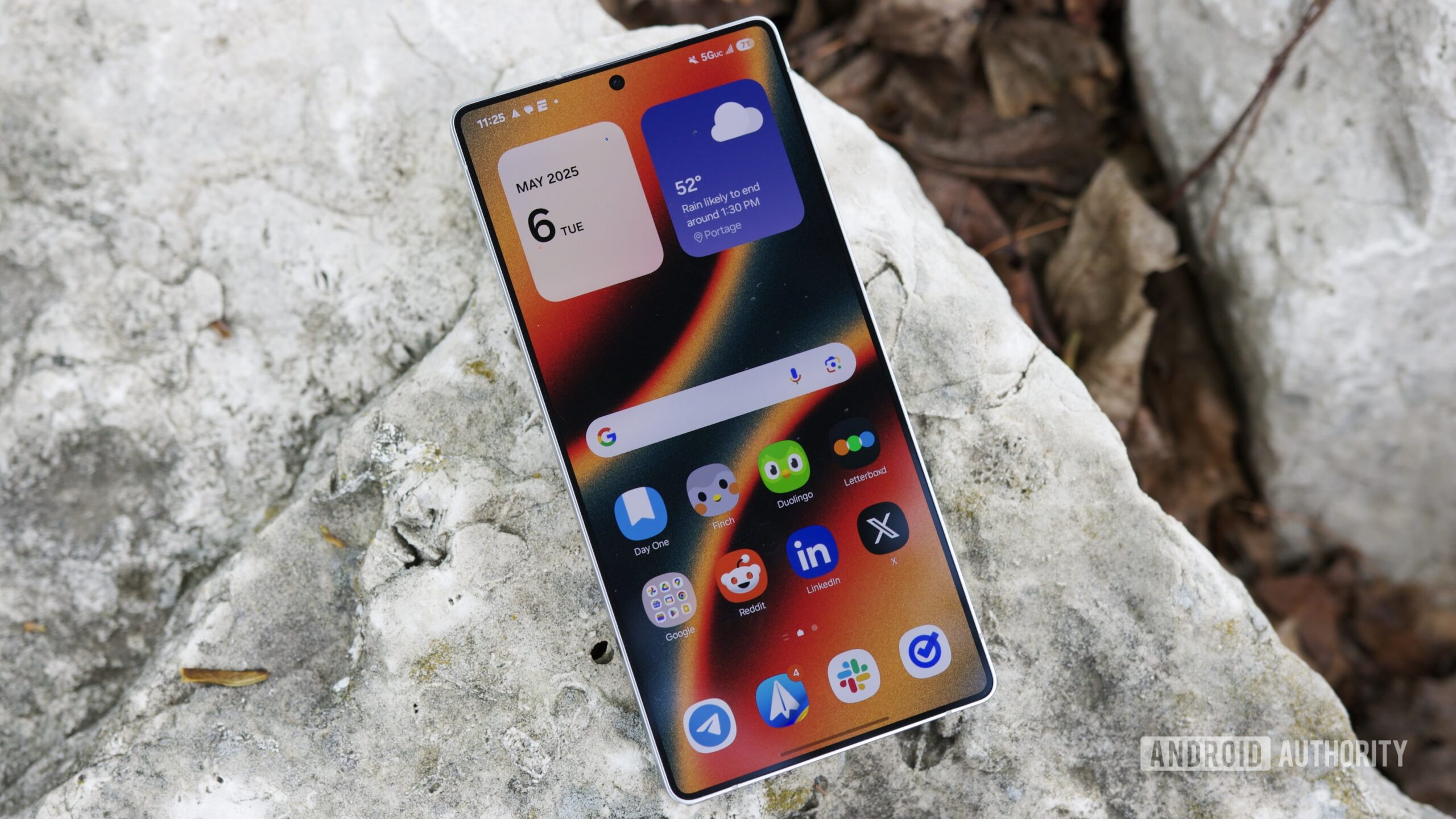 O Samsung Galaxy S25 Ultra colocado do lado de fora com a tela ligada.