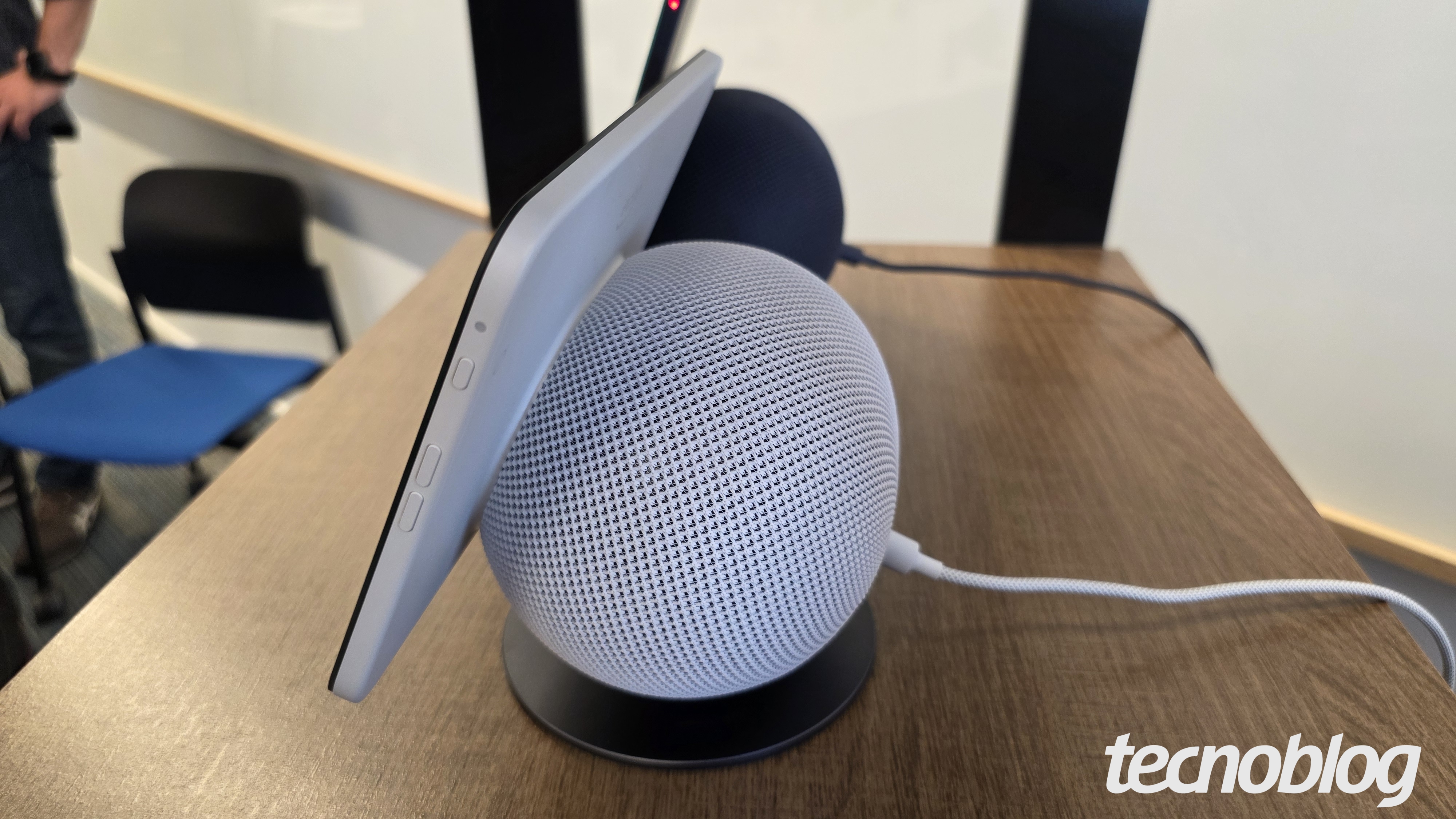 Alto-falante inteligente com tela sobre uma mesa, visto pela lateral